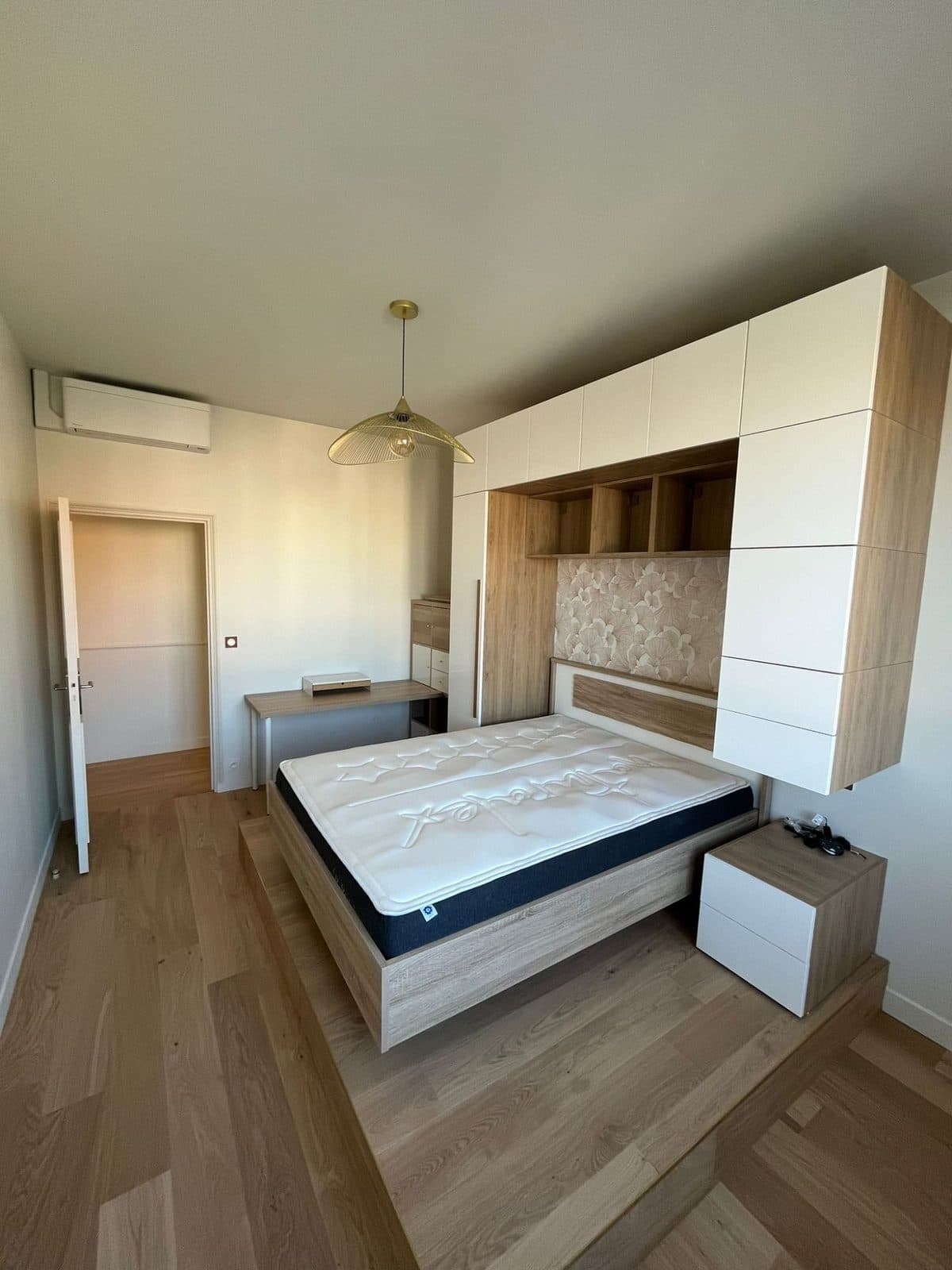 Chambre sur estrade : pont de lit blanc laqué, chevets et parquet chêne